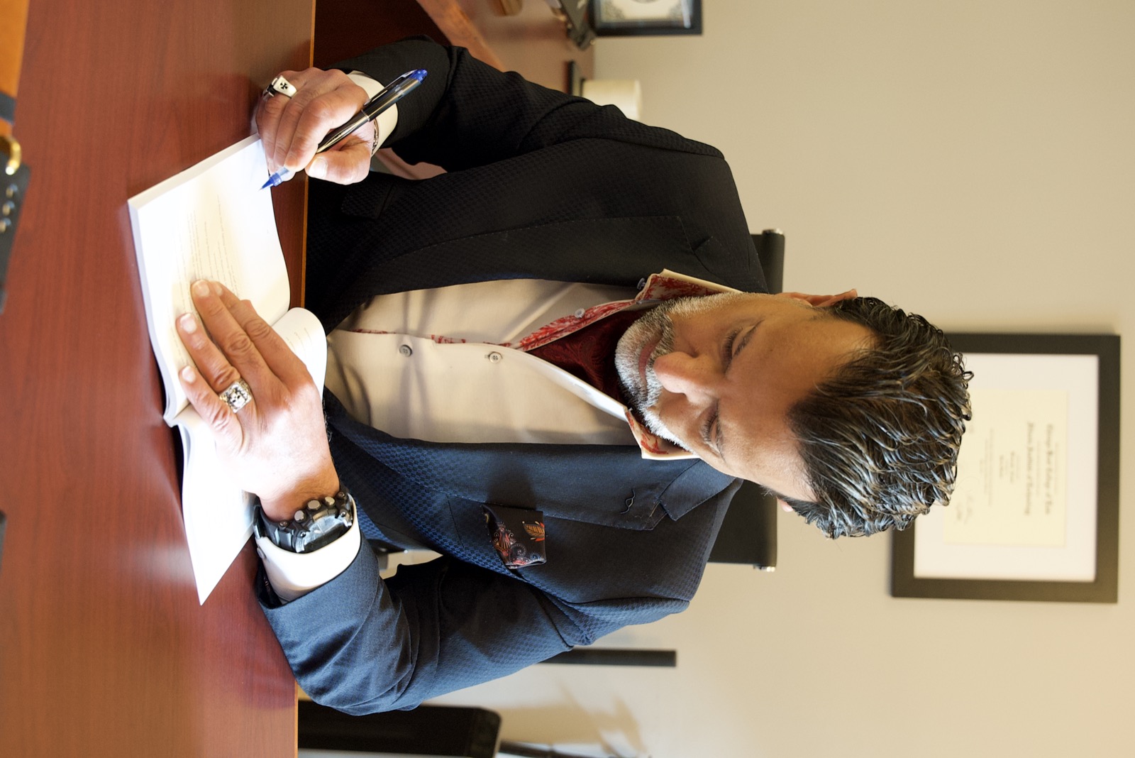 Kourosh Arami reviewing and signing documents at his desk